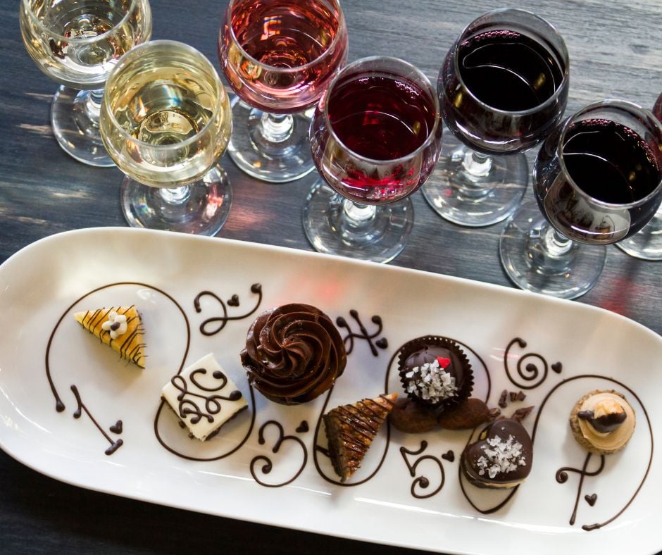 plate of cake slices and glasses of wine